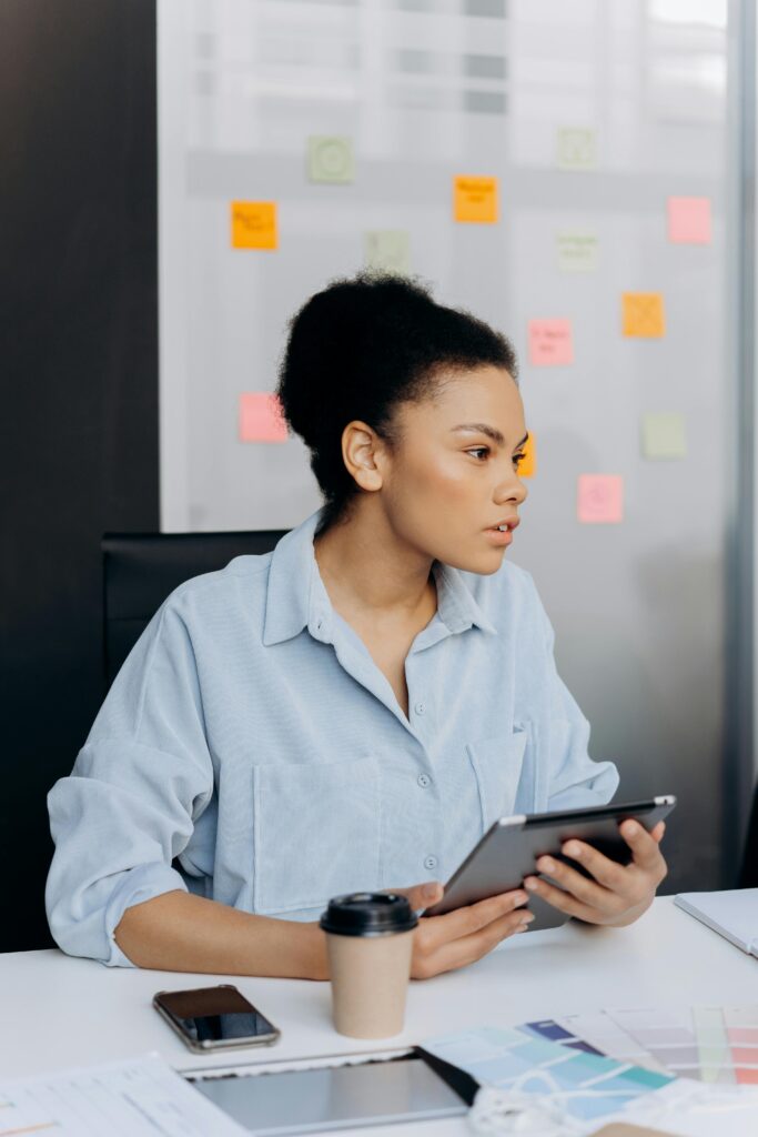 Professional female analyzing work on a tablet in a modern office environment.